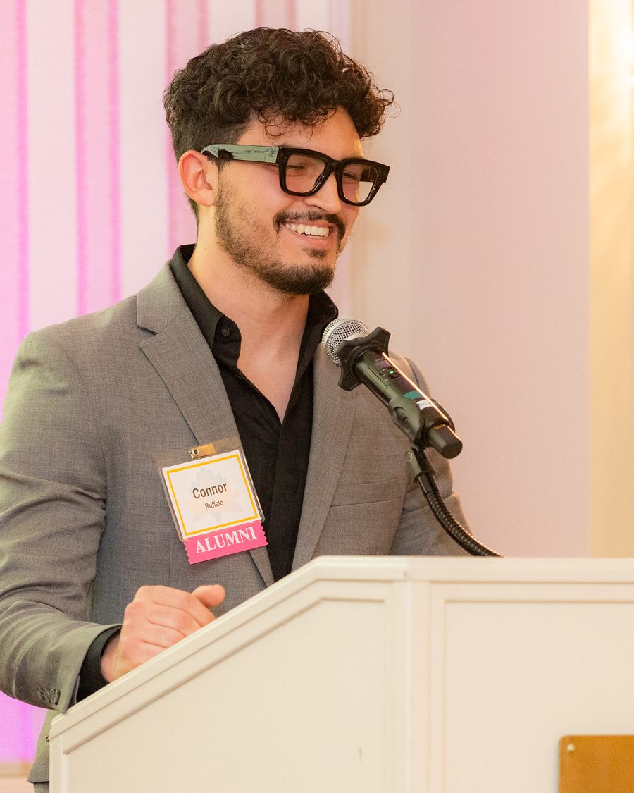 Connor Ruffalo smiling while speaking at an alumni event